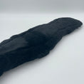Load image into Gallery viewer, Ein schwarzes anatomisches Lammfell der Marke Ascot Reitsportartikel liegt auf einem hellen Untergrund