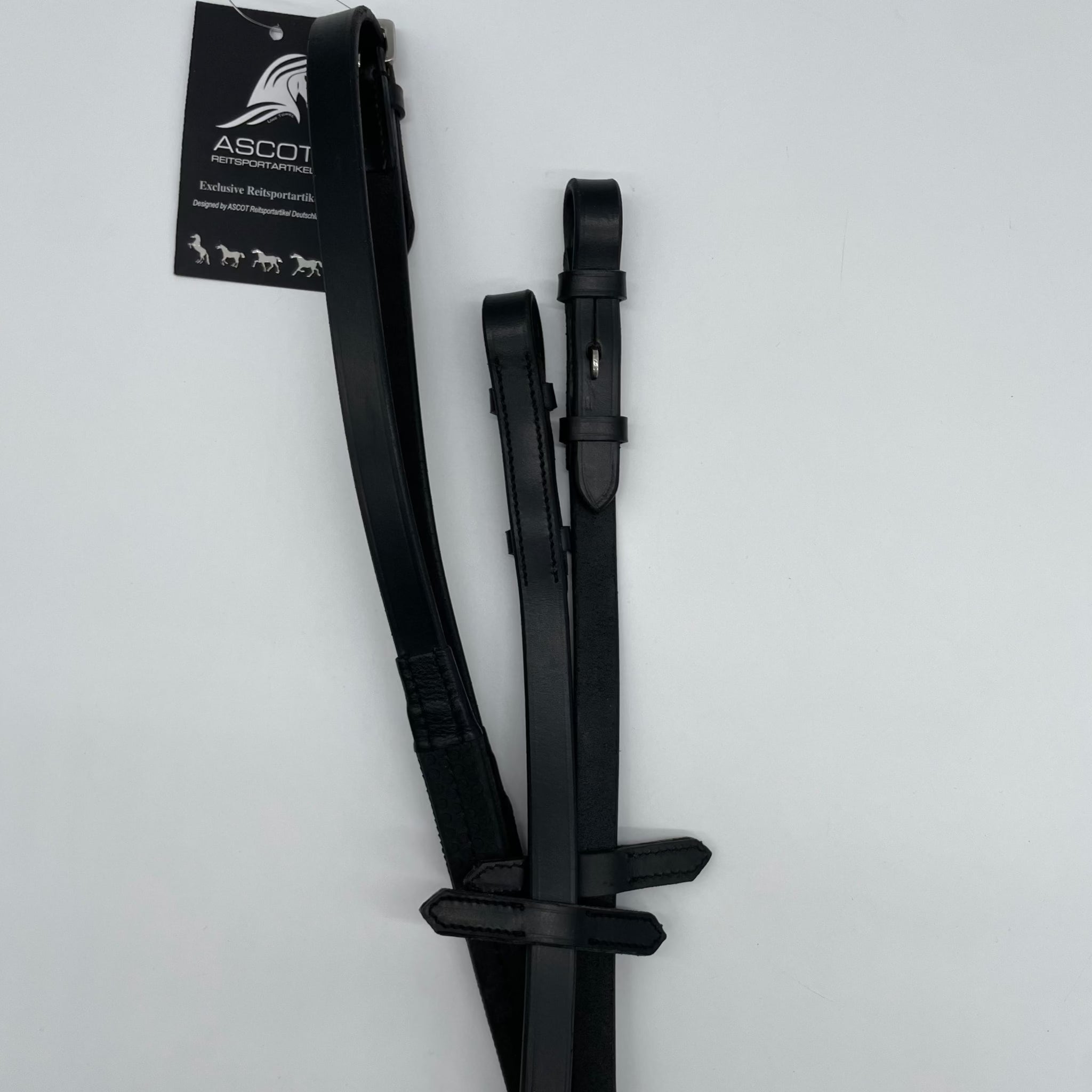 Ein breiter schwarze Gummi-Zügel mit Noppen von der Marke Ascot Reitsportartikel liegt auf einem weißen Untergrund. Dieser besteht aus strapazierfähigem, hochwertigem Material.
