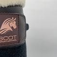 Load image into Gallery viewer, Eine braune Gamasche mit Teddyfellrand und drei Klettverschlüssen von der Marke Ascot Reitsportartikel. Logoausschnitt.